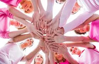 People in pink shirts standing in a circle with hands joined in the centre, symbolizing solidarity for the Day of Pink