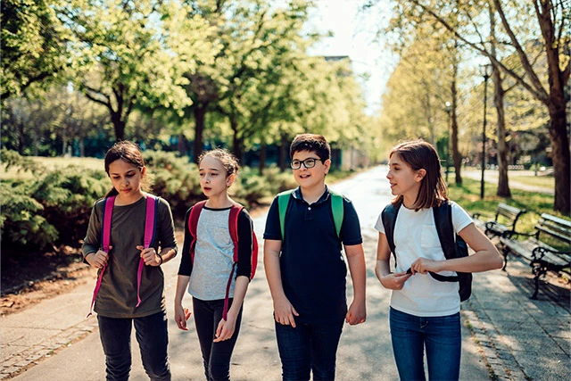 A group of four kids walking outside