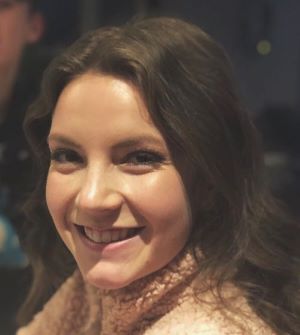 An image of Sarah Lewis smiling in a pink turtleneck