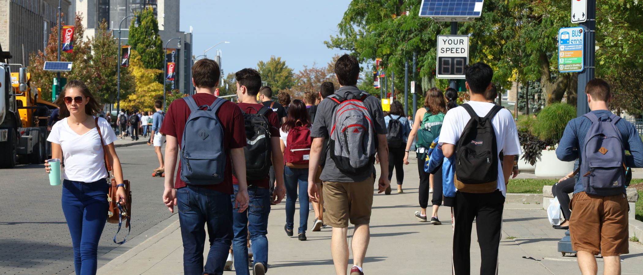 Image of students walking through queen's campus in the fall
