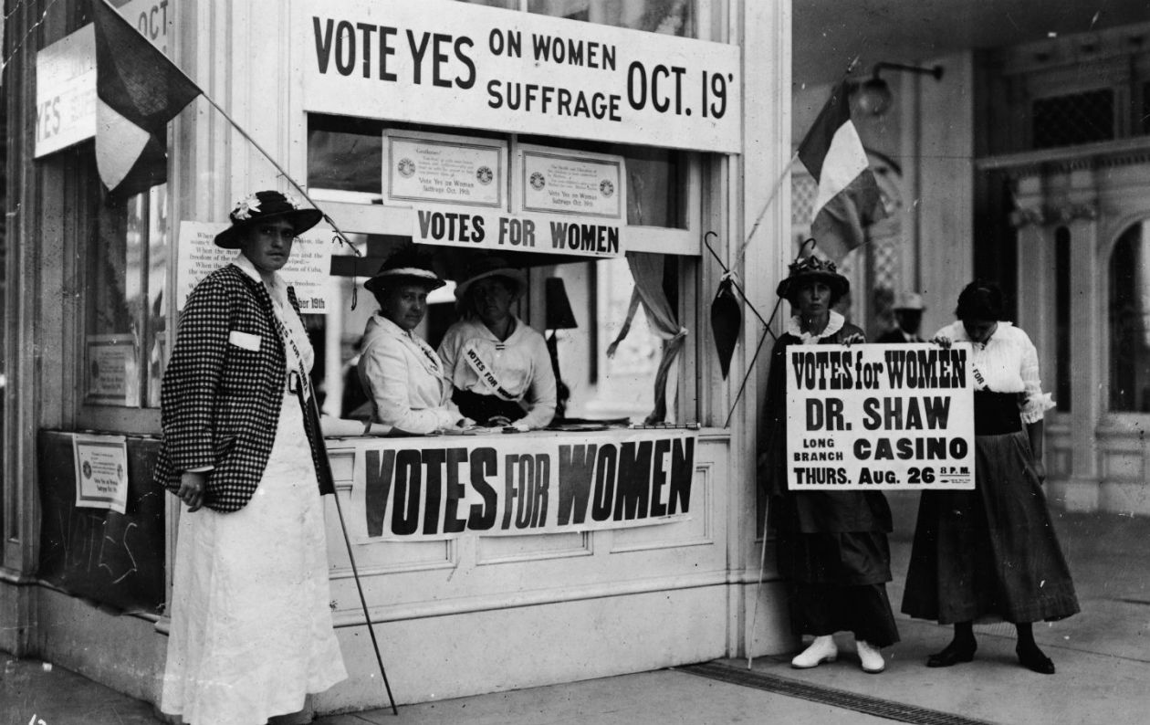 Image of a group of women at a booth fighting for women suffrage