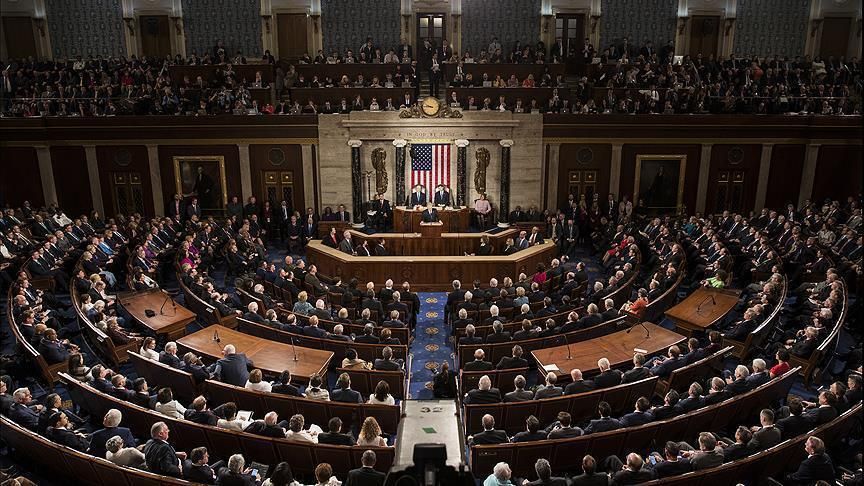 A 2018 photograph of US Congress. A large semi-circle room filled with politicians.