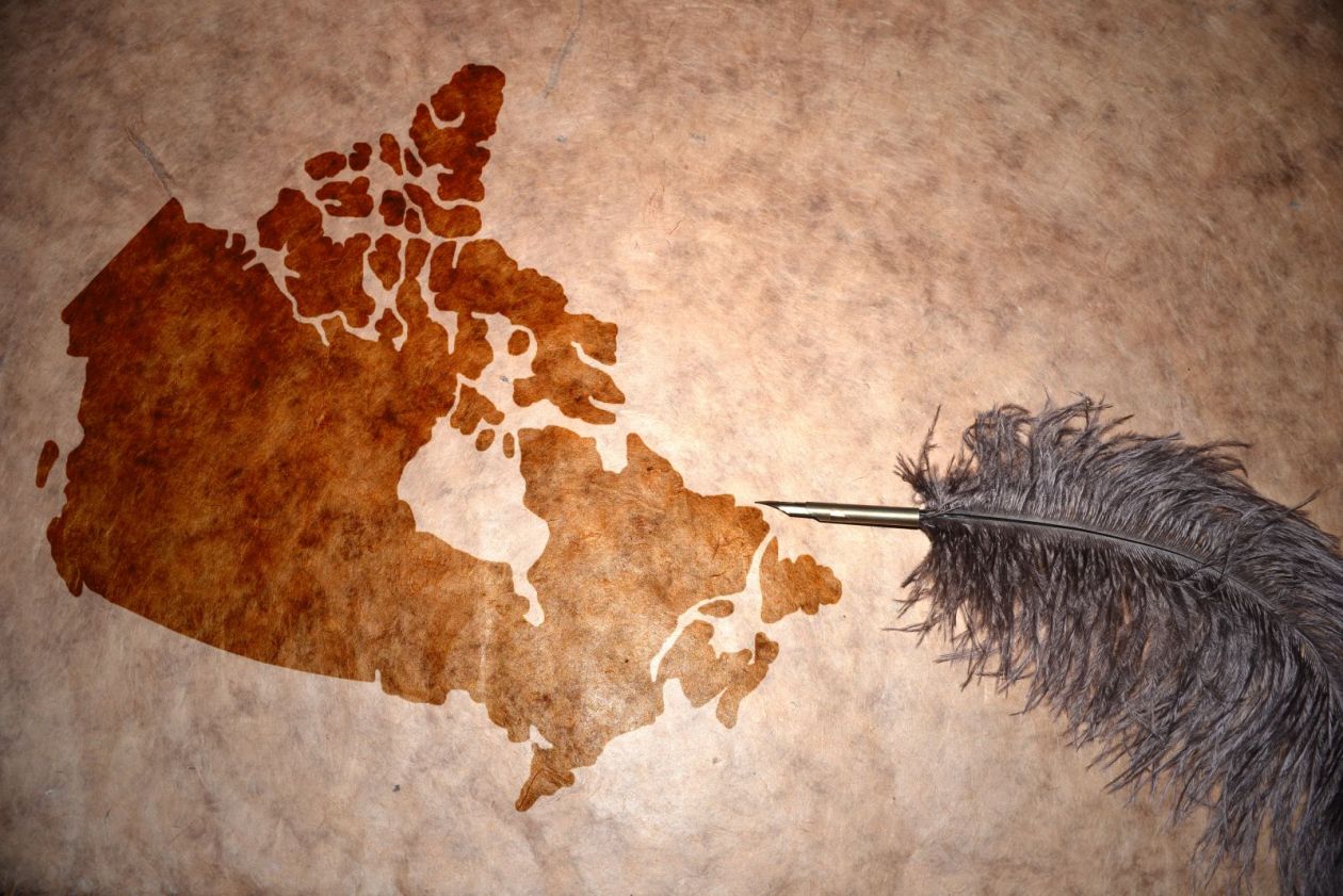 A blank map of Canada with a grey feather alongside it