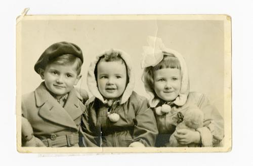 An old image of three young children from 1952 smiling