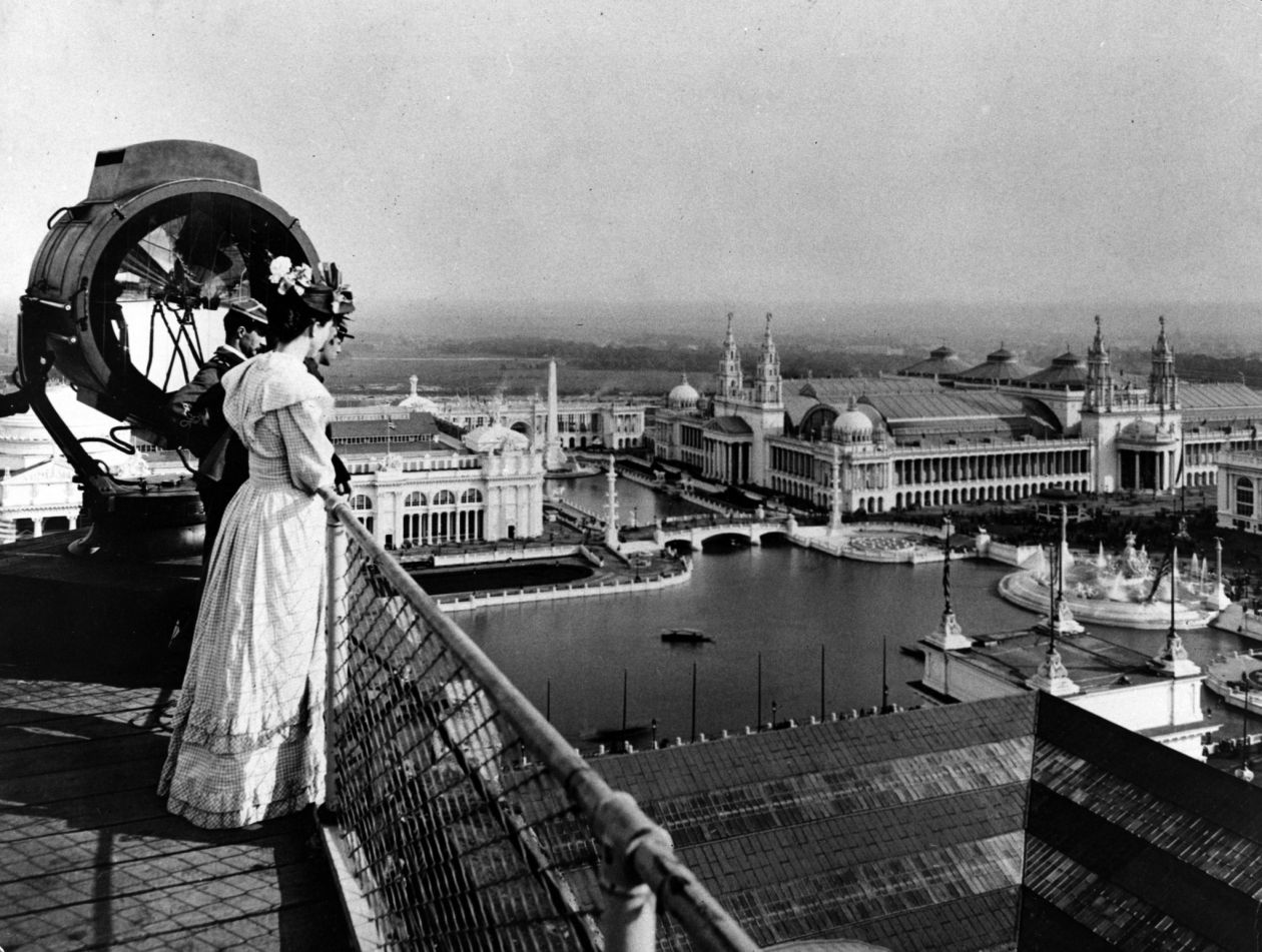 A black and white photograph of a man and woman overlooking the Chicago World Fair