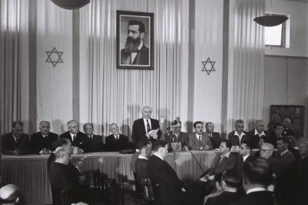 A photo of a group of men in a formal meeting room 