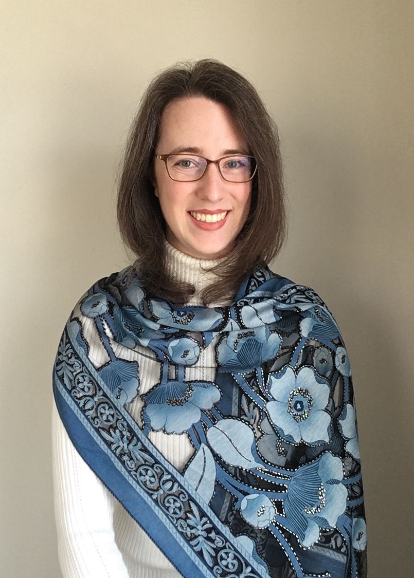 Image of Rebecca Gruskin smiling in a blue scarf