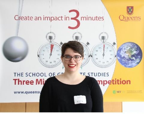 Victoria Cosby in front of a poster for the Queen's Three Minute Thesis Competition