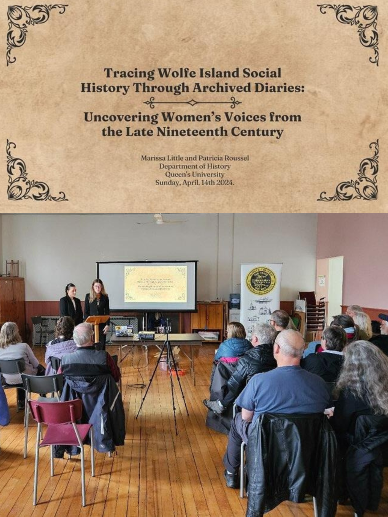 A room full of people sitting at a presentation with two young women standing at the front of the room wearing blazers