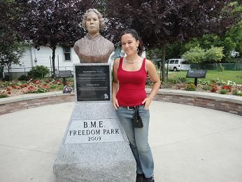 Deirdre McCorkindale stands in front of a statue in a park