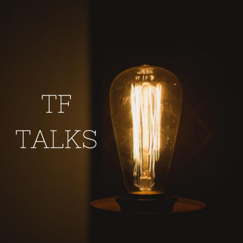 TF Talks poster featuring an Edison lightbulb glowing dimply in a dark room