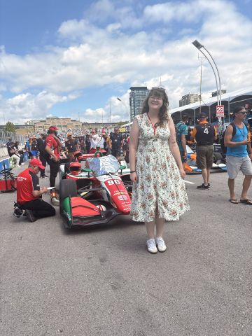 Clio standing in front of an Indycar