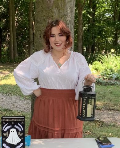 Photo of Kat MacDonald holding a lantern.