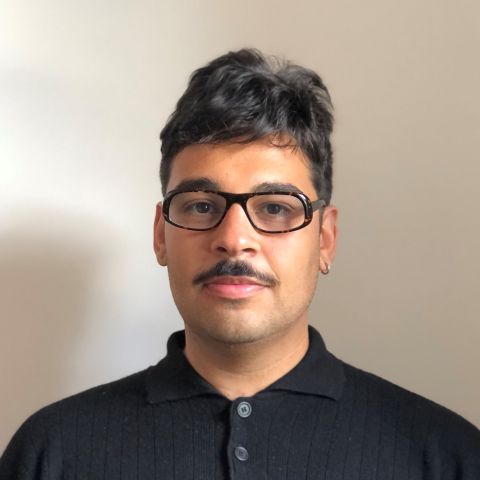 An image of a person with black hair wearing glasses