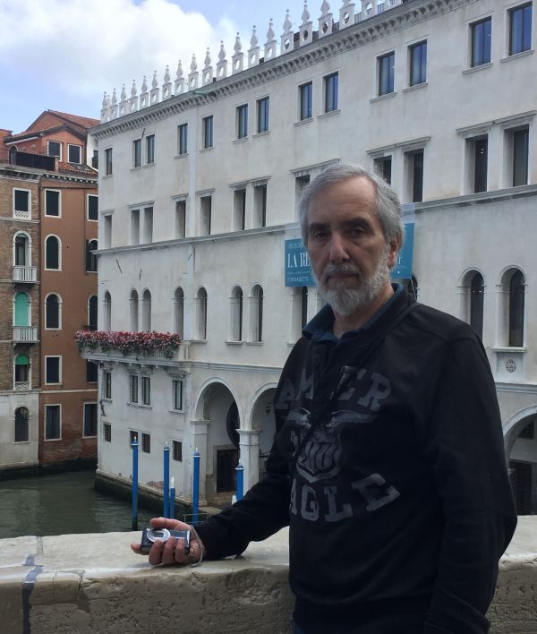 Image of James Cameron standing in front of a historic building with a camera