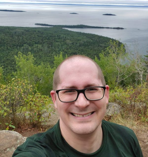 Image of Sean Rodgers smiling overlooking a lake