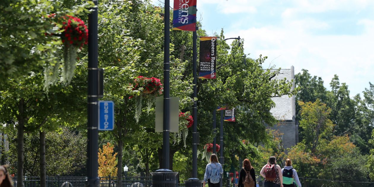 An image of University Avenue with banners featuring Queen's Research hanging from the lampposts