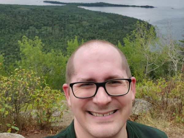 Image of Sean Rodgers smiling overlooking a lake