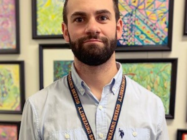 Image of Eric Virtue wearing a Queen's University lanyard 