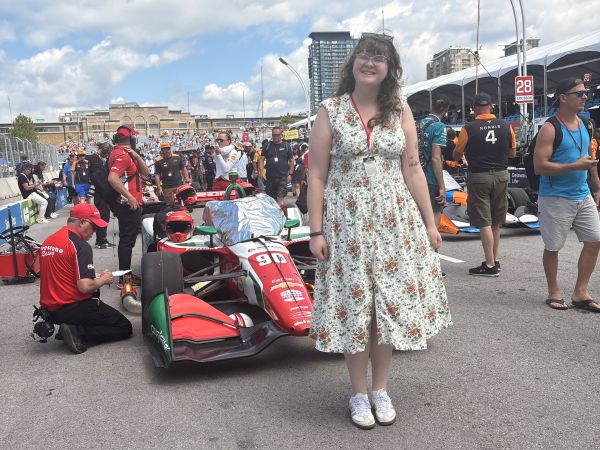 Clio standing in front of an Indycar