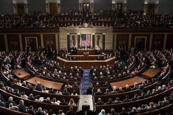 A 2018 photograph of US Congress. A large semi-circle room filled with politicians.