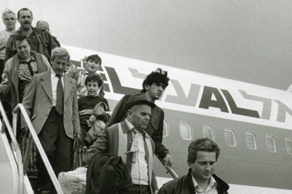A black and white photograph of Jewish people disembarking a plane