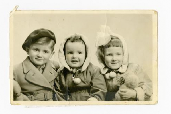 An old image of three young children from 1952 smiling