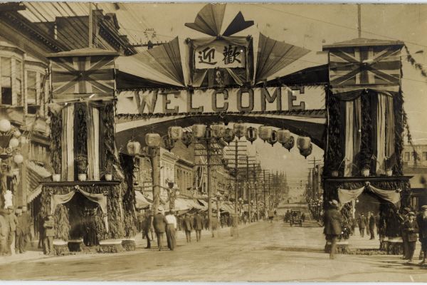 A sepia toned old photograph of a Chinese street arch at Carrall and Pender streets in Vancouver