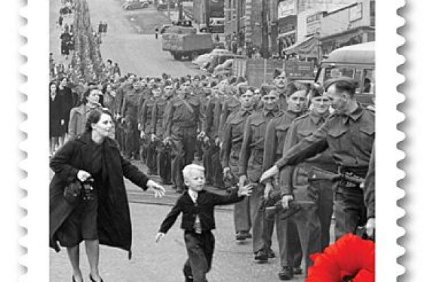 An image of a black and white Canadian stamp shoeing a child running to his father who is in military uniform holding out his hand to reach the child's with text that reads "Wait for me daddy"