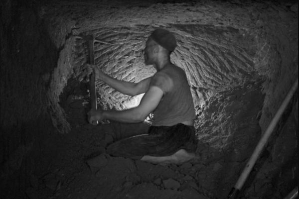 A man mining in a dark cave in Tunisia. 20 February 1960, Redeyef, Tunisia. Photo copyright Gilbert von Raepenbusch, reprinted courtesy of Fonds Beit el Bennani, Tunis, Tunisia