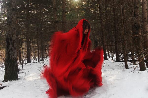 artist Jaime Black in red in wooded area 