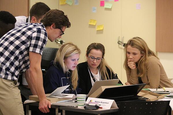 Students working together on their venture. They are all looking at the same screen.