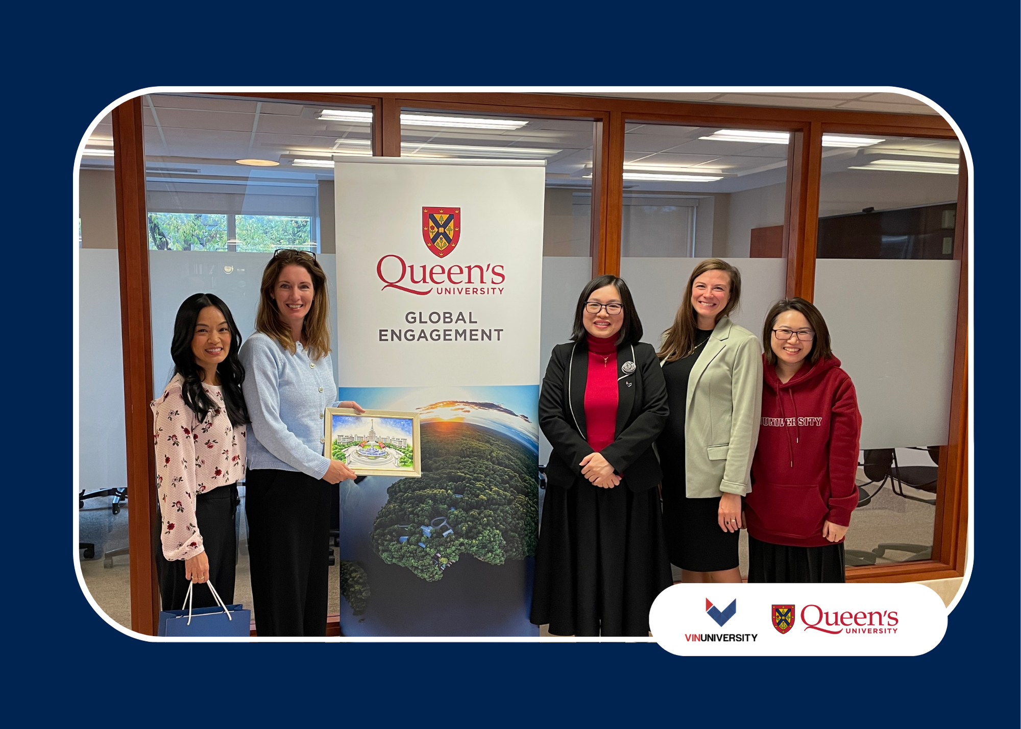 VinUniversity delegation and Queen’s University staff standing beside a Queen’s Global Engagement banner during campus visit.