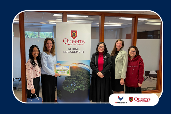 VinUniversity delegation and Queen’s University staff standing beside a Queen’s Global Engagement banner during campus visit.