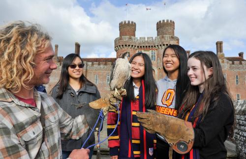 Students learn about falconry with Herstmonceux Castle in the background