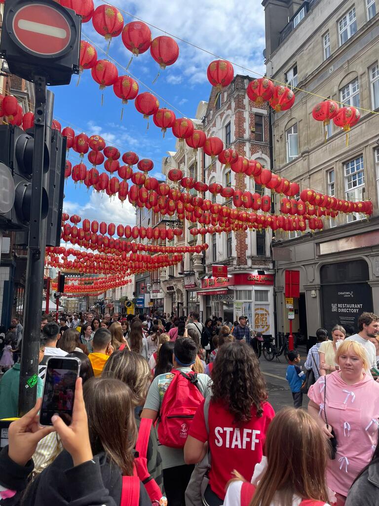 Valerie on a busy Scottish street with red lanterns hanging from the roofs