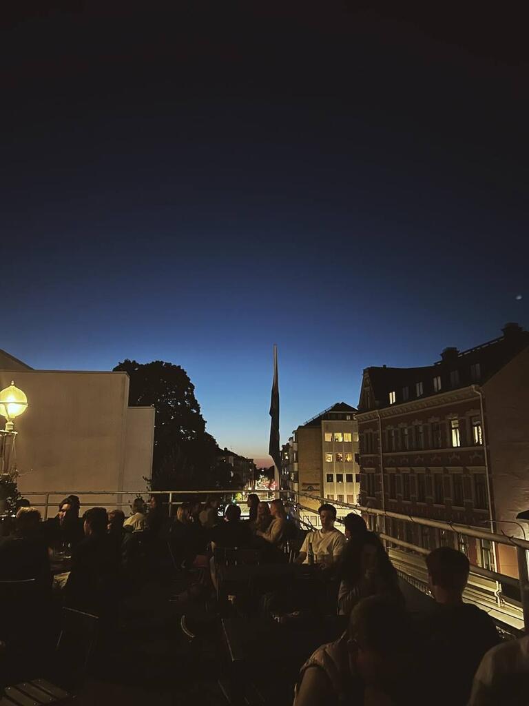 A city skyline taken from a rooftop bar at dusk