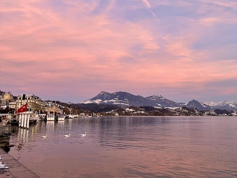 A beautiful sunset view of the water with mountains in the background.