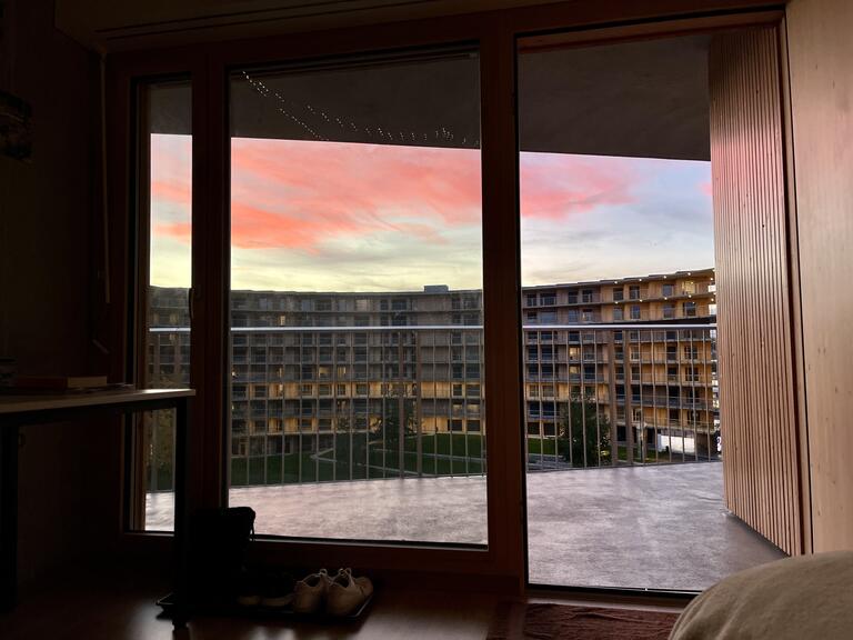 A beautiful view of an apartment complex and a pink sunset.