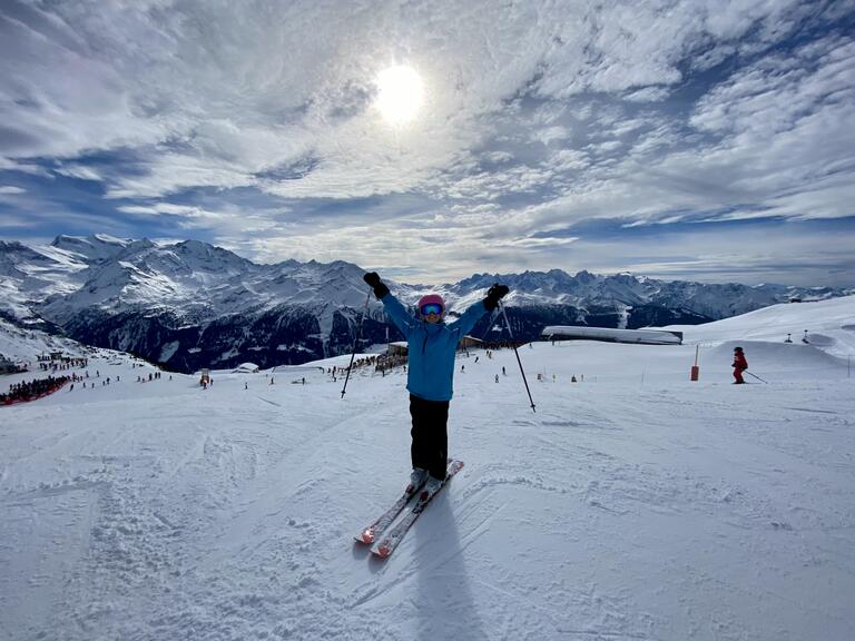 Alyssa skiing with arms outstretched to the sky.