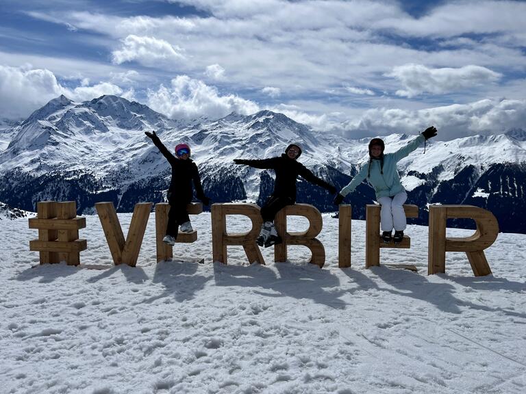 Alyssa and friends posed at the top of a downhill ski mountain.