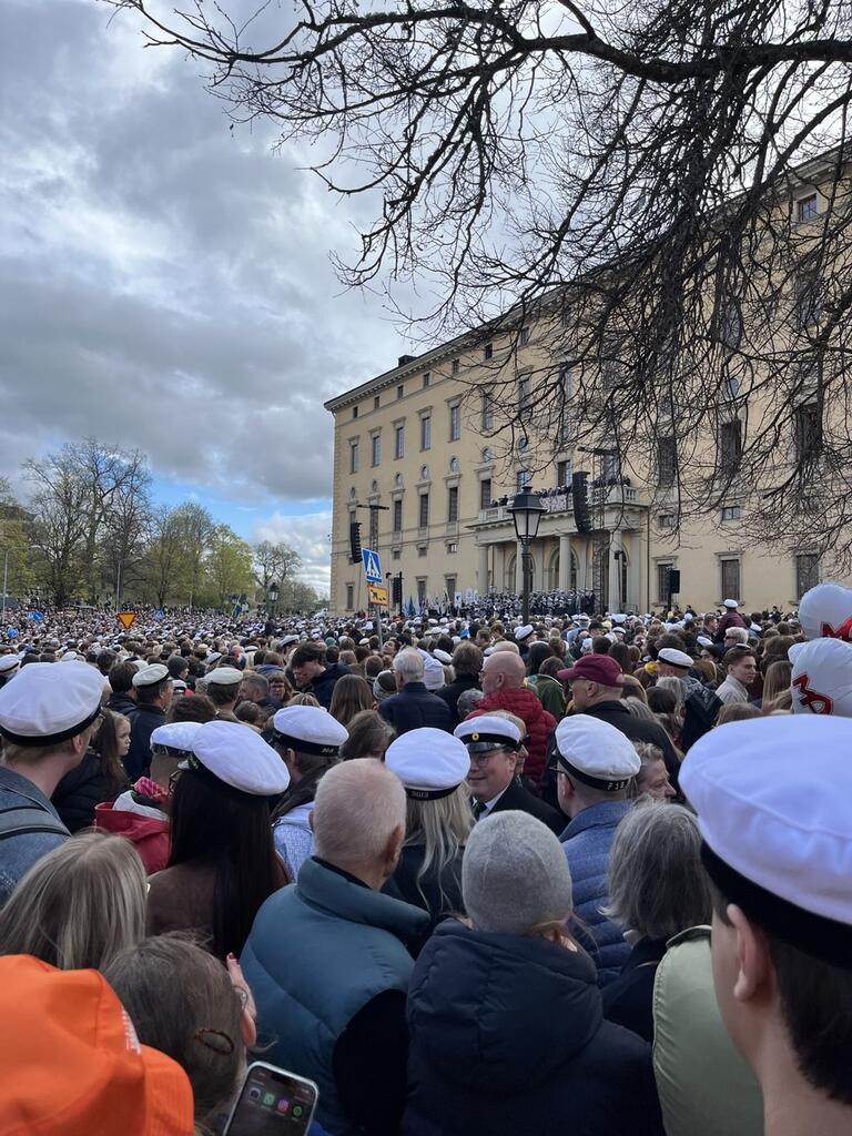 A large outdoor event swarming with people in matching white hats