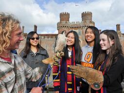 Students learn about falconry with Herstmonceux Castle in the background