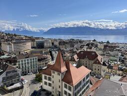 A beautiful rooftop view of the city, with mountains in the background.