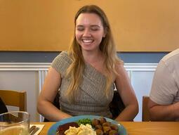Solomiia smiles for the camera with a Swedish meatball meal on the table in front of her.