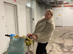 Solomiia poses with a bicycle in a furry jacket