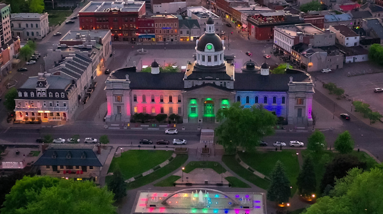 Aerial view of downtown with City Hall at night lit up with red, blue, and green lights