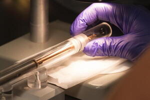 Image of gloved hand testing sample research from nuclear reactor