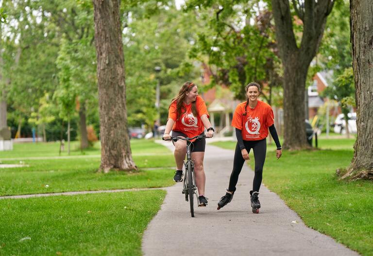 Two students biking on a trail