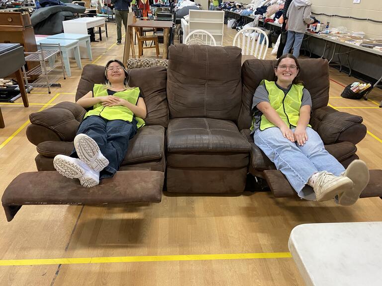 two volunteers sitting on a donated couch